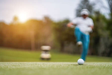 Golfer playing golf in the evening golf course, on sun set evening time. Man playing golf on a golf course in the sun.の写真素材