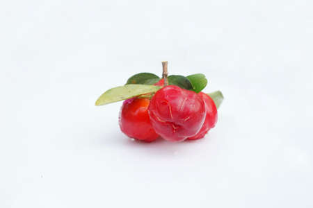 Fresh acerola fruit, typical from Brazil. Red organic Acerola Cherry with half slice and green leaves isolated on white background, High vitamin C and Antioxidant fruitsの写真素材