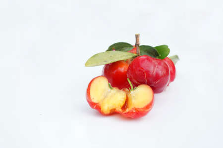 Fresh acerola fruit, typical from Brazil. Red organic Acerola Cherry with half slice and green leaves isolated on white background, High vitamin C and Antioxidant fruitsの写真素材