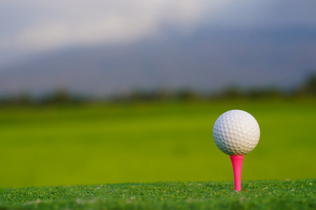 Golf ball on the green with warm tone and sunset. Golf ball on Green field golf course in morning time with soft sunlight.の写真素材