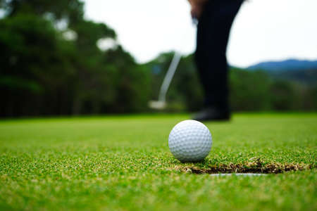 Blurred golfer playing golf in beautiful golf course in the evening golf course with sunshine in thailand.の写真素材