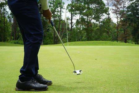 Blurred golfer playing golf in beautiful golf course in the evening golf course with sunshine in thailand.の写真素材