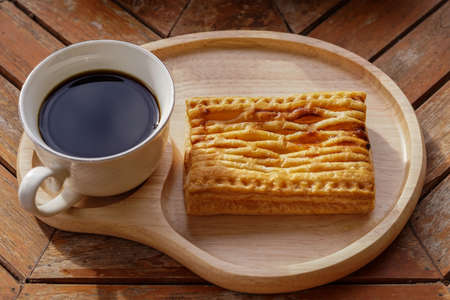 Cup of black coffee with cake on wooden table.の写真素材