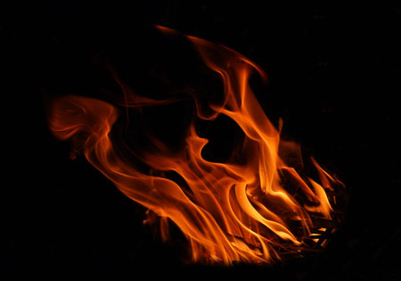 Stack of thermal energy close-up, red and yellow, heat energy igniting fuel during night/light on black background.の写真素材
