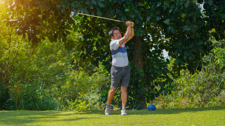 Golfer playing golf in the evening golf course, on sun set evening time, Man playing golf on a golf course in the sun.の写真素材