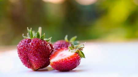 Red strawberries on white wooden table and farmland backgroundの写真素材