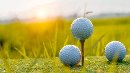 Golf ball is on pink tee on green grass background, White Golf ball on tee on green grass of golf course with copy space.の写真素材