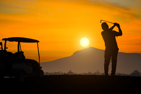 silhouette golfer playing golf with golf cart during beautiful sunset, concept healthy, copy space for put textの写真素材