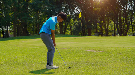 Golfer playing golf in the evening golf course, on sun set evening time, Man playing golf on a golf course in the sun.の写真素材