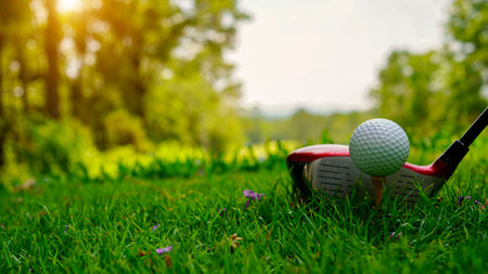 Golf ball and golf club in a beautiful golf course in Thailand. Collection of golf equipment resting on green grass with green backgroundの写真素材