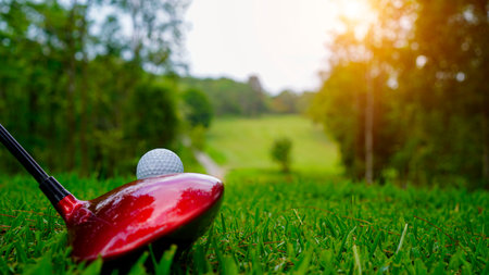 Golf ball and golf club in a beautiful golf course in Thailand. Collection of golf equipment resting on green grass with green backgroundの写真素材