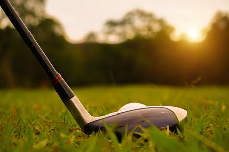 Golf ball and golf club in beautiful golf course at sunset background.の写真素材