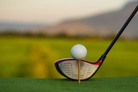Golf ball and golf club on green in a beautiful golf course with morning sunshine.Ready for golf in the first short.の写真素材