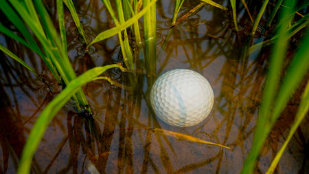 golf ball in water hazard. Problems and obstacles of Golf balls are in danger from water. Problems and obstacles of golfers. White golf ball falls into the water One of the obstacles to playing golfの写真素材