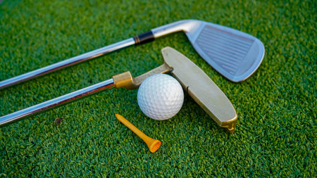 Golf clubs and golf balls on a green lawn in a beautiful golf course with morning sunshine. Close up...