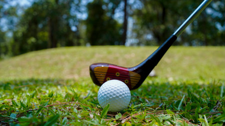 Golf club and ball in green grass. Golf balls on the golf course with golf clubs ready for golf in the first short. In the morning, with the beautiful sunlight.の写真素材