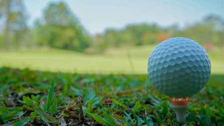 Close-up of golf ball on tee in beautiful golf course at sunset background. Ready for golf in the first short.の写真素材
