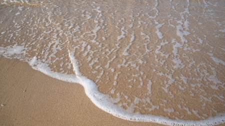 Soft waves of the blue ocean on the sandy beach. Selective focus background. Beautiful Soft blue ocean wave on fine sandy beach Summer background conceptの写真素材