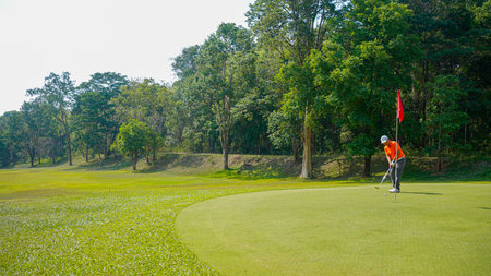 Golfer are playing game golf and hitting go on green grass mountain background. Asia male player game shot in summer. Sport holiday lifestyle concept.の写真素材