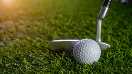 Golf clubs and balls on a green lawn in a beautiful golf course with morning sunshine. Close up of...
