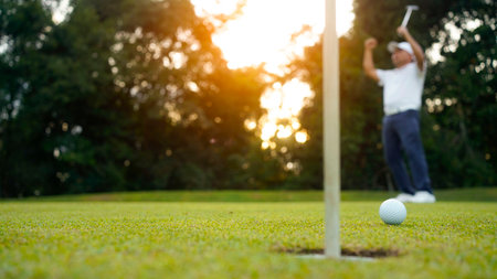 Golfers are putting golf in the evening golf course golf backglound. Golfer hitting golf ball. Sport holiday lifestyle Concept.の写真素材