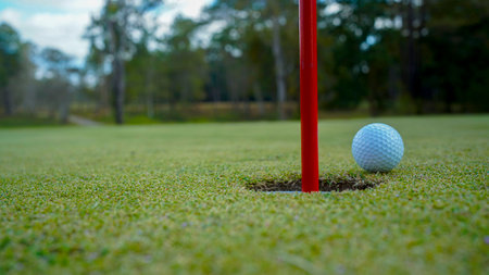 Top view. Golf hole on a green grass in the evening golf course with sunshine background.の写真素材