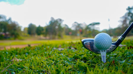 Golf clubs and golf balls on a green lawn in a beautiful golf course with morning sunshine. Close up of golf equipment on green grass.の写真素材