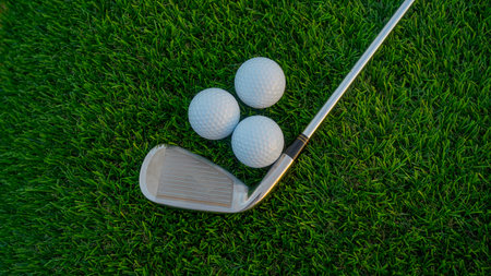 Golf clubs and golf balls on a green lawn in a beautiful golf course with morning sunshine. Close up...