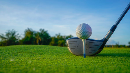 Golf clubs and balls on a green lawn in a beautiful golf course with morning sunshine. Close up of golf equipment on green grass.の写真素材
