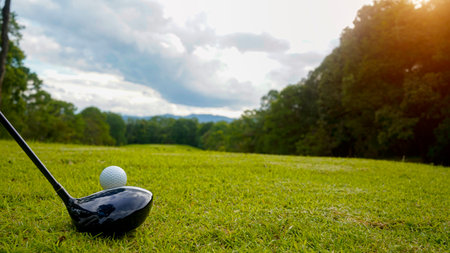 Golf clubs and balls on a green lawn in a beautiful golf course with morning sunshine. Close up of...