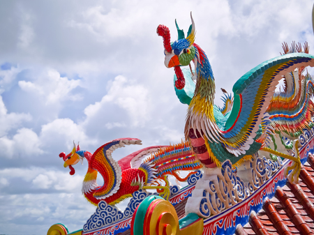 red and green phoenix birds on top the roof in Chinese templeの写真素材