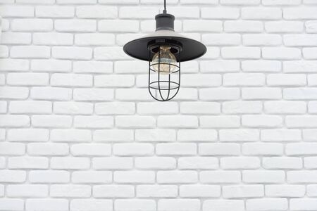 vintage lamp hanging from the ceiling with white brick wallの写真素材
