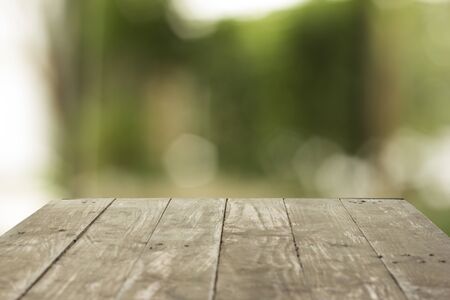 Empty wood table top on forest background. can montage or display your productsの写真素材