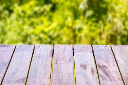Empty wood table top on forest background. can montage or display your productsの写真素材