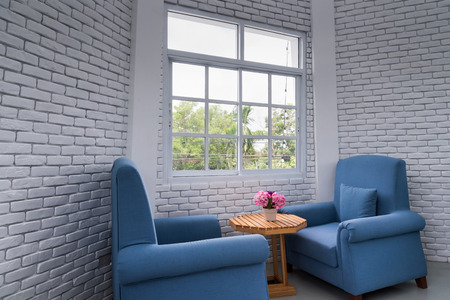 blue classic armchair in modern loft living room with white brick wallのeditorial素材