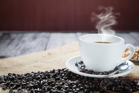 Coffee cup and beans on a rustic background. Coffee Espresso and a curl. Cup Of Coffee and coffee beans on tableの写真素材