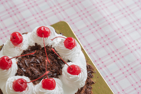 Black forest cake decorated with whipped cream and cherriesの写真素材