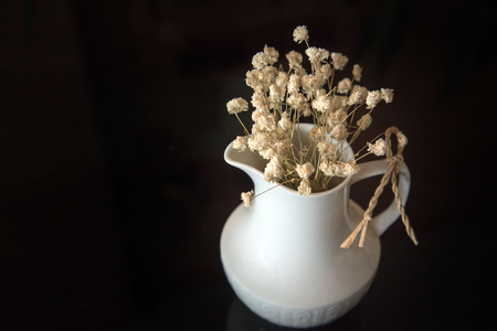 Dried flowers in a vase on dark backgroundの写真素材