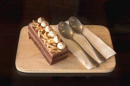 chocolate cake topping almond with cream on woodenの写真素材