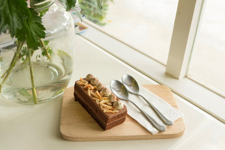 chocolate cake topping almond with cream on wooden