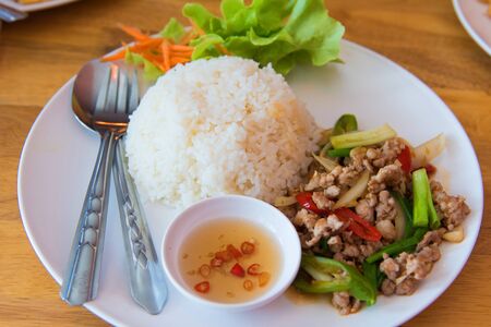 Rice Basil Pork in plate on wooden table