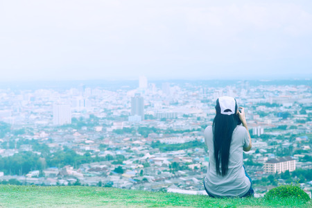 Woman sitting on the lookout City View shooting with the camera DSLRの写真素材