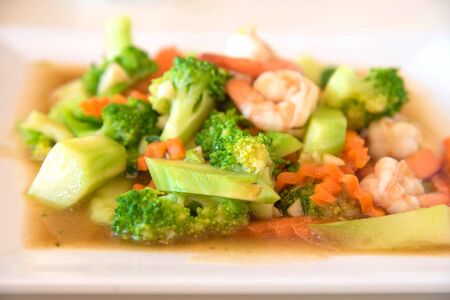 healthy food stir-fried broccoli, carrot and shrimp on plateの写真素材