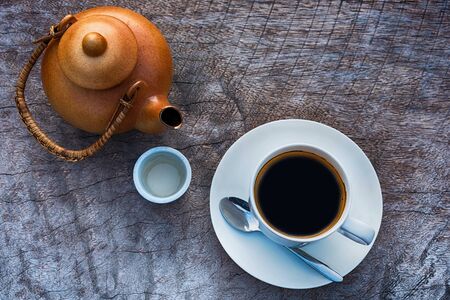 Coffee cup with Hot pot made of clay  put on a wooden tableの写真素材