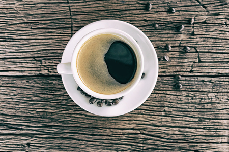 Coffee cup and beans on wooden tableの写真素材