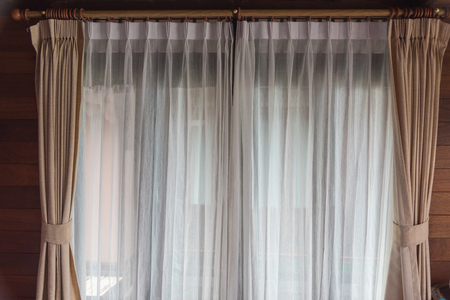 Room window with white and Cream curtainsの写真素材