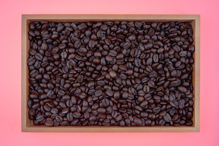 coffee beans in box on pink backgroundの写真素材