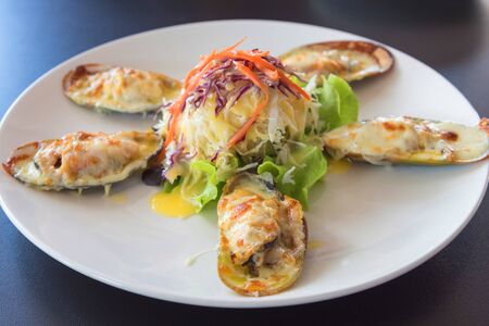 mussels under cheese and salad, Mussels baked with cheese and garlic ,Toasts with basil and garlic,Italian food,Home madeの写真素材