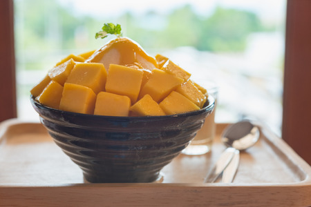 Bingsu ( Korea food) mango served with sweetened condensed milk on table, Mango Bingsu Korea dessert poured mango sauce.の写真素材