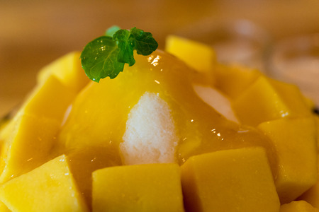 Bingsu ( Korea food) mango served with sweetened condensed milk on table, Mango Bingsu Korea dessert poured mango sauce.の写真素材
